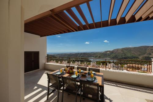 a balcony with a table and chairs with a view at Modern penthouse with two terraces, jacuzzi and sea, lake and mountain views, in Almazara Hills in Istán