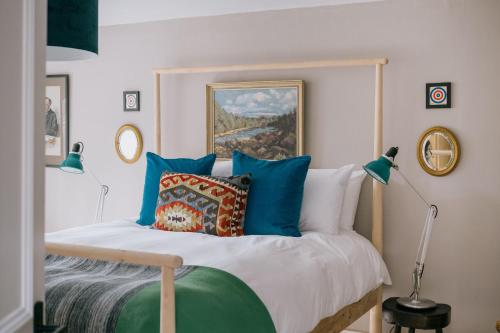 a bedroom with a bed with blue pillows at Gamekeeper's Cottage in Banchory