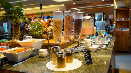 a buffet line with jars of food on a counter at Hot Beach Resort in Olímpia