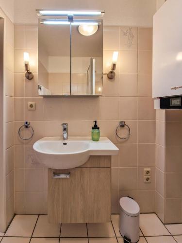 a bathroom with a sink and a mirror and a toilet at Strandmuschel in Greetsiel