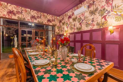 a dining room with a table with flowers on it at Seclude Tea Estate, Palampur in Pālampur