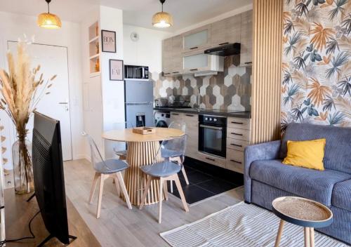 un salon avec un canapé bleu et une table dans l'établissement Entre Paris et Disneyland avec charme intérieur, à Noisy-le-Grand