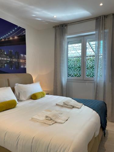 a bedroom with a large white bed with a window at Bnbook Martina's house in Castelletto sopra Ticino