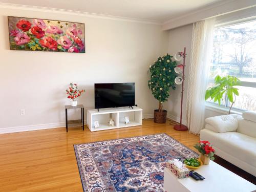 a living room with a couch and a tv at Sunny House - Main Floor, Free parking, in Toronto in Toronto