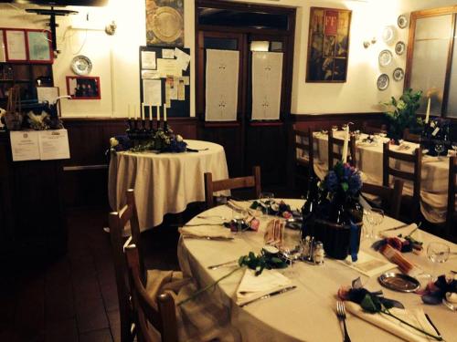 a dining room with tables with white tablecloths and flowers at Agriturismo Cascina del Vai in Cairo Montenotte
