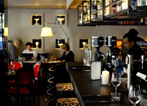 a bar with people sitting at tables in a restaurant at Hotel Villa Emilia in Barcelona