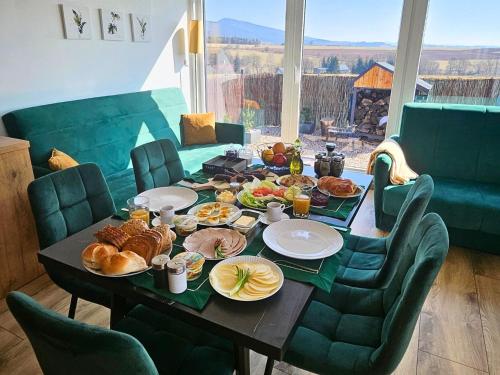 a table with breakfast foods on top of it at Rajska polana Domki PREMIUM ,na odludziu z prywatną BALIĄ z jacuzzi i sauną ,Cisza,rowery elektryczne,góry,astroprzygoda,- Adršpach, Skalne Miasto, Zamek Książ,Andrzejówka,Karpacz, Śnieżka,Janskie Laznie,Pec in Mieroszów