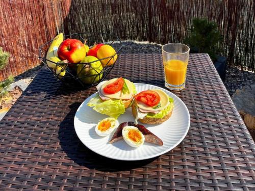 a plate of food with eggs and fruit and a glass of orange juice at Rajska polana Domki PREMIUM ,na odludziu z prywatną BALIĄ z jacuzzi i sauną ,Cisza,rowery elektryczne,góry,astroprzygoda,- Adršpach, Skalne Miasto, Zamek Książ,Andrzejówka,Karpacz, Śnieżka,Janskie Laznie,Pec in Mieroszów