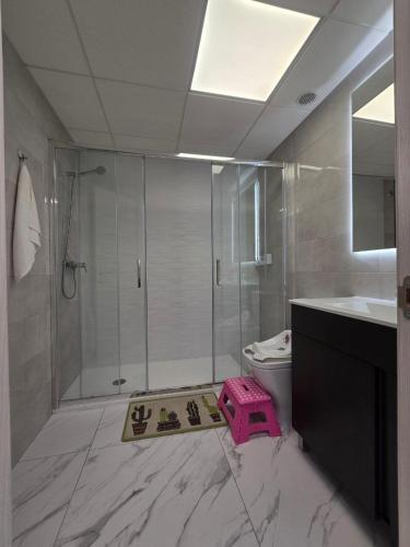 a bathroom with a shower and a scale on the floor at Luxury Beachfront Family Apartment in La Pineda