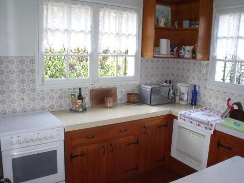 une cuisine avec une cuisinière et un micro-ondes dans l'établissement Capriga, à Arès