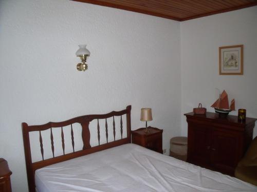 a bedroom with a bed and a dresser and a lamp at Capriga in Arès