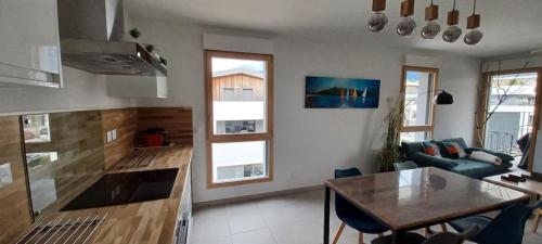 une cuisine et un salon avec une table et des chaises dans l'établissement La parenthèse du lac - Lake view and private parking, à Aix-les-Bains