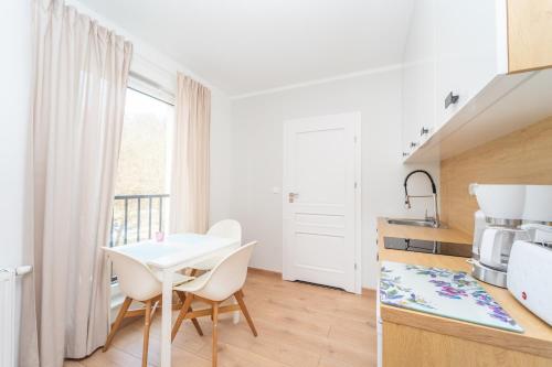 a kitchen with a white table and chairs in a room at Comfortable 3city Studios in Sopot by Noclegi Renters in Sopot