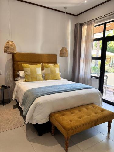 Un dormitorio con una cama grande con almohadas amarillas. en Somer House Guest Suites, en Somerset West