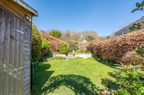 a garden with a fence and a grass yard at Bulldog Cottage in Ampleforth