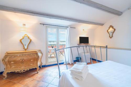 a bedroom with a bed and a tv and a window at Al Palmento Relais in Siracusa