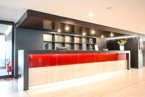 a lobby with a red and black reception counter at Hotel Selene Pomezia in Pomezia