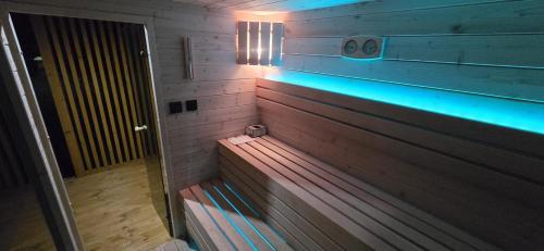 a wooden bench in a room with blue lights at Domki letniskowe Marengo in Lubiatowo