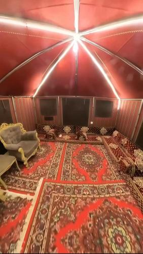 a room with a red wall with a large rug at مسكن كازان in Abha