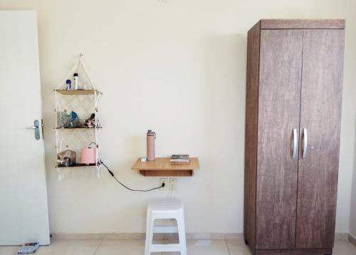 a room with a wooden door and a stool next to a wall at Casa Amarela na Praia de Guaibim-Taquari in Guaibim