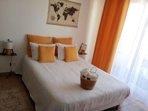 a bed with orange pillows and a basket on it at B301 Disney Paris AppartementAppartement in Montévrain