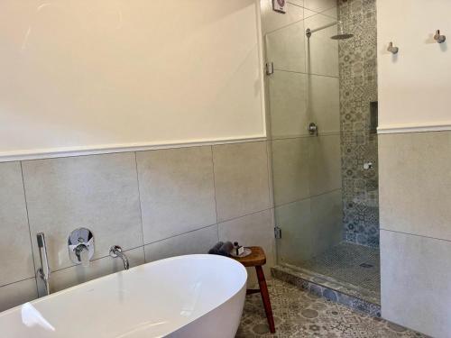 a bathroom with a tub and a shower at Keerweder Cottages in Franschhoek