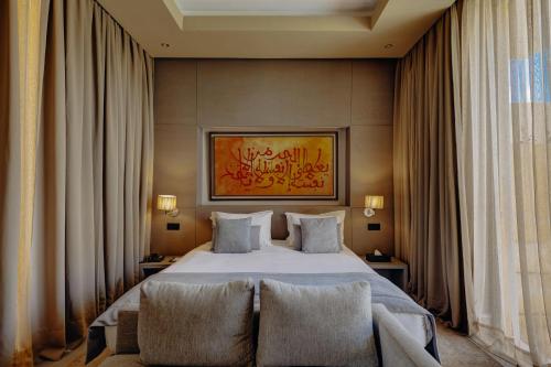 a hotel room with a bed and two chairs at Sirayane Boutique Hotel & Spa Marrakech in Marrakesh