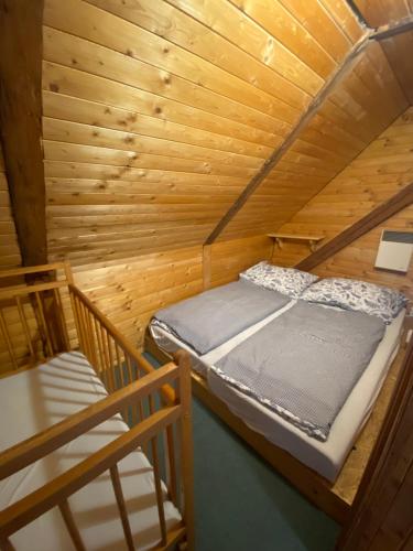 a bedroom with a bed in a wooden cabin at Penzion Zvonička in Trutnov