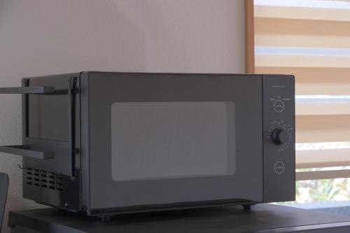 a black microwave oven sitting on top of a table at Villa Lotus in Kamakura