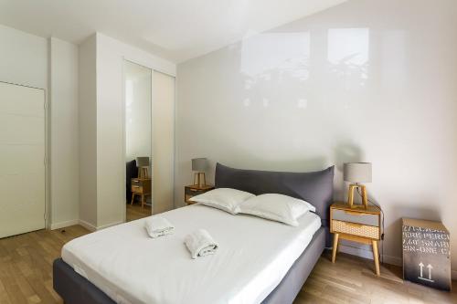 une chambre avec un grand lit blanc avec deux oreillers dans l'établissement DIFY Sedallian - Vaise, à Lyon