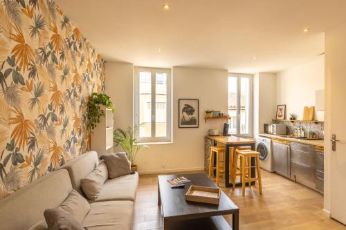 un salon avec un canapé et une cuisine dans l'établissement Lou Pistou Appartement lumineux près de la plage, à Martigues