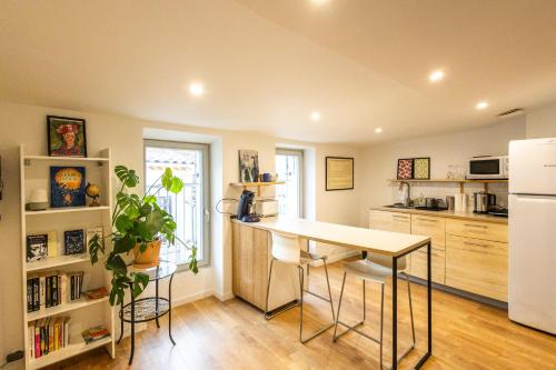 une cuisine avec une table et un réfrigérateur blanc dans l'établissement Calisson Appartement lumineux et cosy près des plages, à Martigues