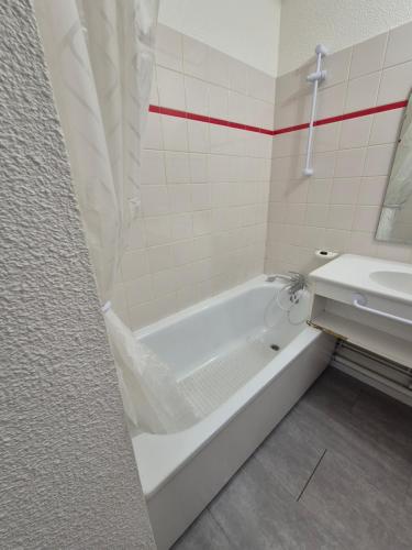 a bathroom with a white tub and a sink at Résidence les Mélèzets 2 au pieds des pistes et des commerces in Modane