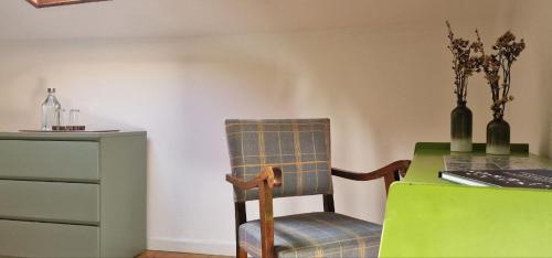 a chair sitting next to a table with a desk at A-Típica GuestHouse in Ponta Delgada