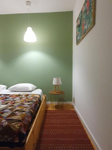 a bedroom with a bed and a table with a lamp at A-Típica GuestHouse in Ponta Delgada