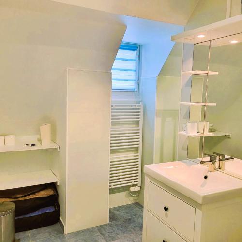 une salle de bain blanche avec un lavabo et un miroir dans l'établissement Maison village, 10 pers, proche de la plage, à Audinghen
