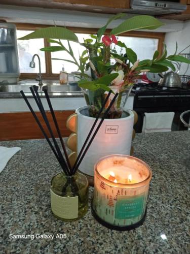 a candle and a vase with flowers on a counter at ESPERANZA Pension House & Restaurant in Roxas