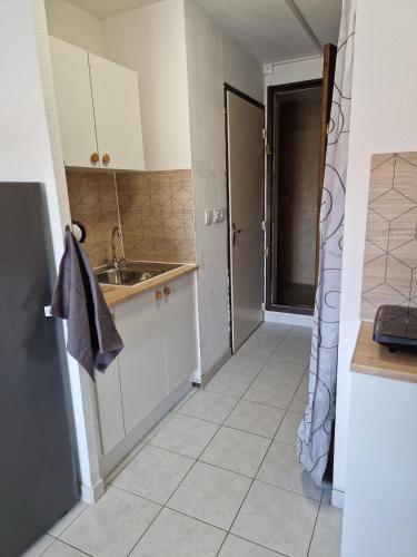 une cuisine avec un évier et un plan de travail dans l'établissement Vue lac & mer à pied - Séjour détente, à Port-la-Nouvelle