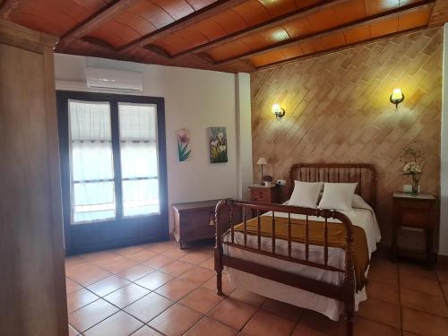 a bedroom with a bed and a window and a door at La Moreneta in Casas de Haro