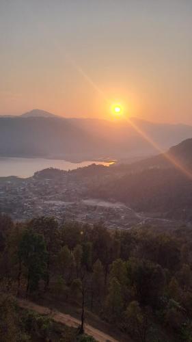 a sunset with the sun rising over a city at Kailash villa and restro in Pokhara
