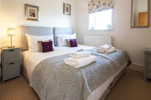 a bedroom with a bed with towels on it at Howells Mere 47, Robin Lodge in Somerford Keynes