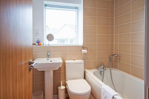a bathroom with a toilet and a sink and a tub at Howells Mere 47, Robin Lodge in Somerford Keynes