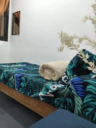 a bed with a pillow on top of a couch at Barnwood Homestay in Talap