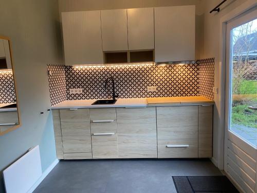 a kitchen with wooden cabinets and a window at Blokhut Klein Meerzicht in Haren
