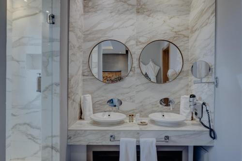 a bathroom with two sinks and two mirrors at Sirayane Boutique Hotel & Spa Marrakech in Marrakesh