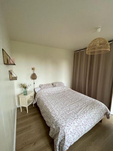 une chambre blanche avec un lit et une fenêtre dans l'établissement Maisonnette de charme, à Quemper-Guézennec