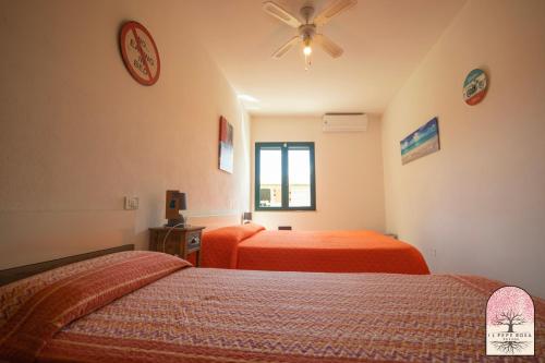 a bedroom with two beds and a ceiling fan at Il Pepe Rosa in Posada