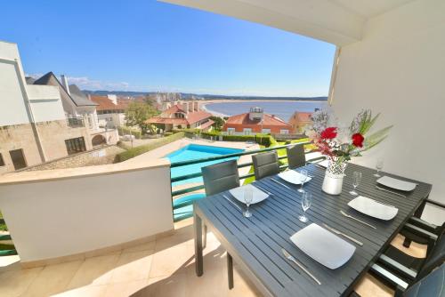 a table and chairs on a balcony with a pool at Bay in São Martinho do Porto