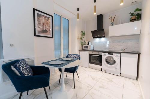 une cuisine avec une table et une machine à laver dans l'établissement Chambre avec Balnéo, centre ville de Nice, à Nice