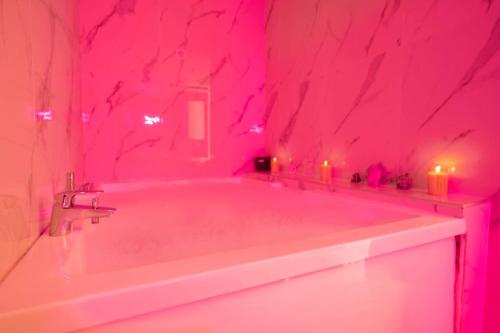 d'une salle de bains rose pourvue d'une baignoire avec des bougies. dans l'établissement Chambre avec Balnéo, centre ville de Nice, à Nice